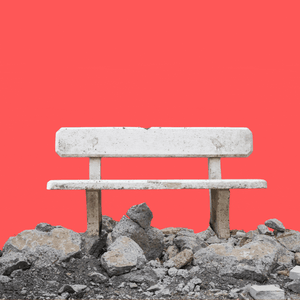 A stone bench appearing from a pile of cement. 