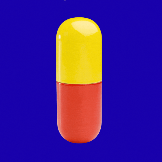 A yellow and red pill capsule opens and several small, multi-colored particles spill out.