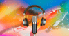 A microphone and pair of headphones against a rainbow background.