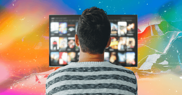 The back of a man’s head in front of a television screen.