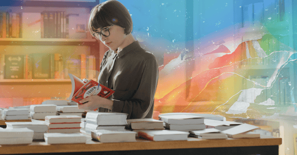 A woman holding an open book in a bookstore on a rainbow background.