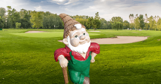 A garden gnome on a golf course.