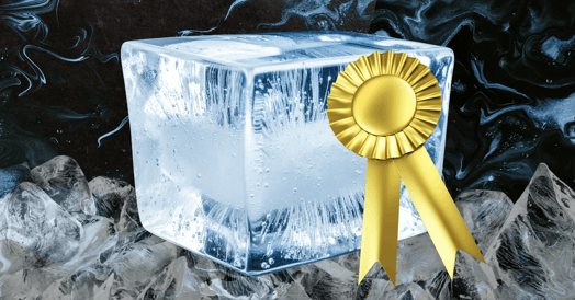 A block of ice with a gold ribbon on it. 
