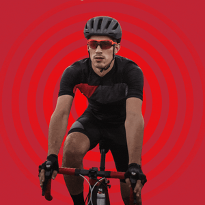 A man in cycling clothes, gloves, and a helmet riding a bike.