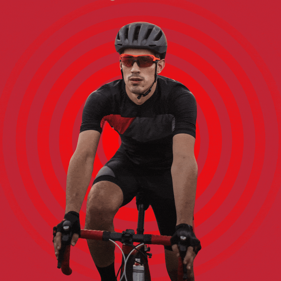 A man in cycling clothes, gloves, and a helmet riding a bike.