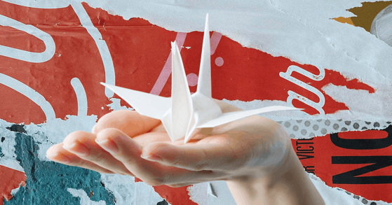 A hand holding a paper crane.