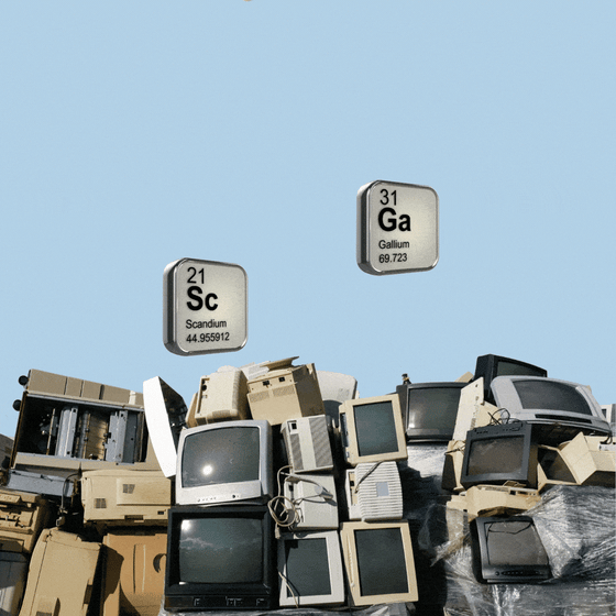 Several tiles, depicting various elements on the periodic table, emerging from a heap of old computers.