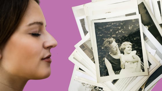 A woman sniffs a collection of black and white photographs.