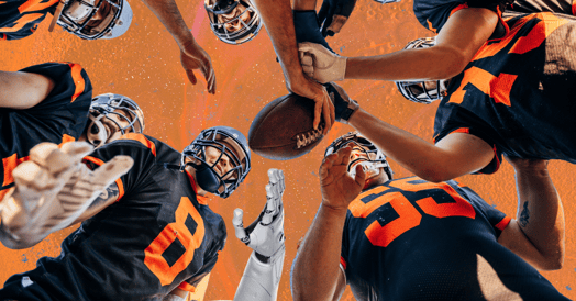 Football players putting their hands in for a huddle with one white robot arm.