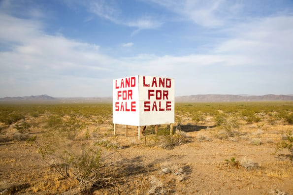 Land for sale sign in desert area.