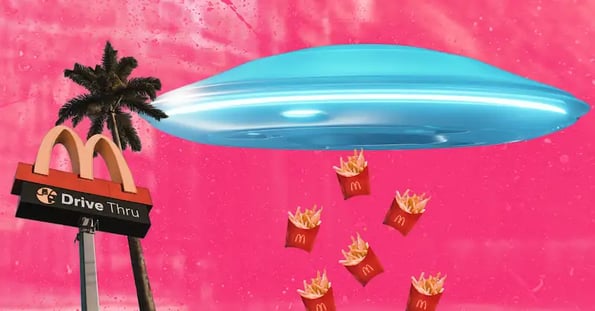 A silver-blue flying saucer with a stream of McDonald’s fries underneath hovers near a McDonald’s sign.