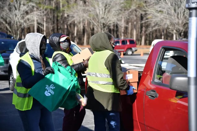 volunteers loading food in vehicles