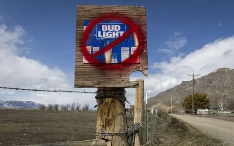 A sign disparaging Bud Light beer is seen along a country road.