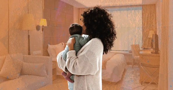 A curly haired mom holding her baby, both facing away.