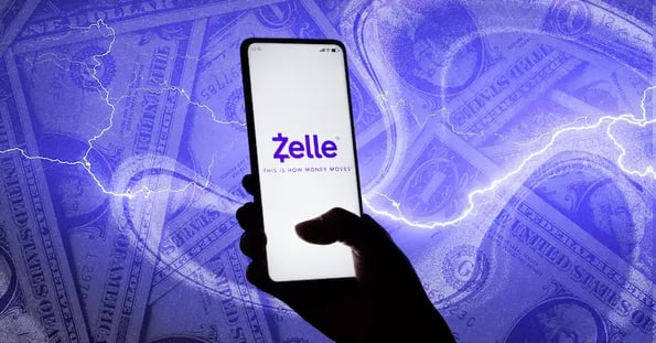 A silhouetted hand holds a smartphone with Zelle’s logo on the screen against a purple backdrop featuring lightning bolts and dollar bills.