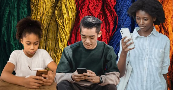 Three young people reading on their smartphones against a multicolored background made up of thread.