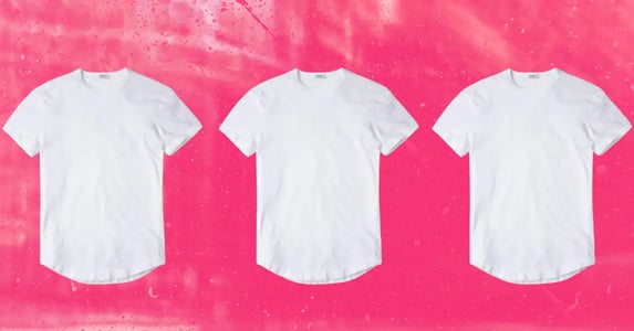 Three white T-shirts aligned in a horizontal row on a pink background.