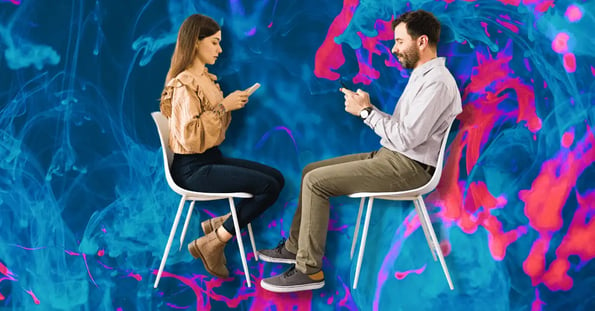 A man and woman sitting across from each other in chairs, both texting.