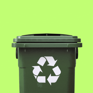 A banana peel and a bone are dropped into a green recycling bin.