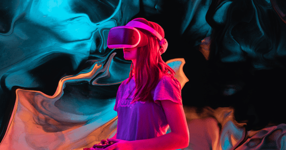 A woman wears a virtual reality headset and holds a VR controller against a blue and peach background.
