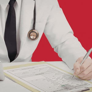A man in a white lab coat, white shirt, and black tie with a stethoscope around his neck sits at a desk, marking a patient file with red circles and arrows. He is only visible from the neck to waist.
