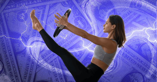 A woman in fitness apparel performs a V sit holding a weight plate.