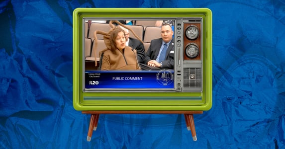 A green retro-style TV. On its screen is a woman dressed in a cockroach costume speaking at a city council meeting.