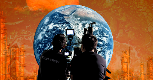 Two men in black T-shirts holding film equipment pointed at an image of Earth on an orange background with the faint outlines of smokestacks.