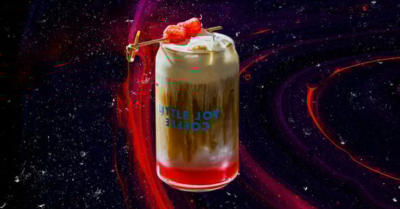 A raspberry danish latte from Little Joy Coffee in a branded glass. (Little Joy Coffee)