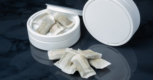 A white tin of white nicotine pouches.