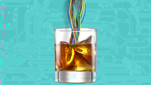 A cup of whiskey with wires being poured into it